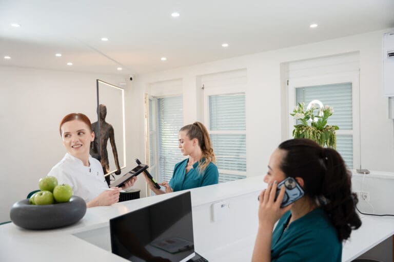 Empfangsbereich der Praxis mit dem Team im Gespräch